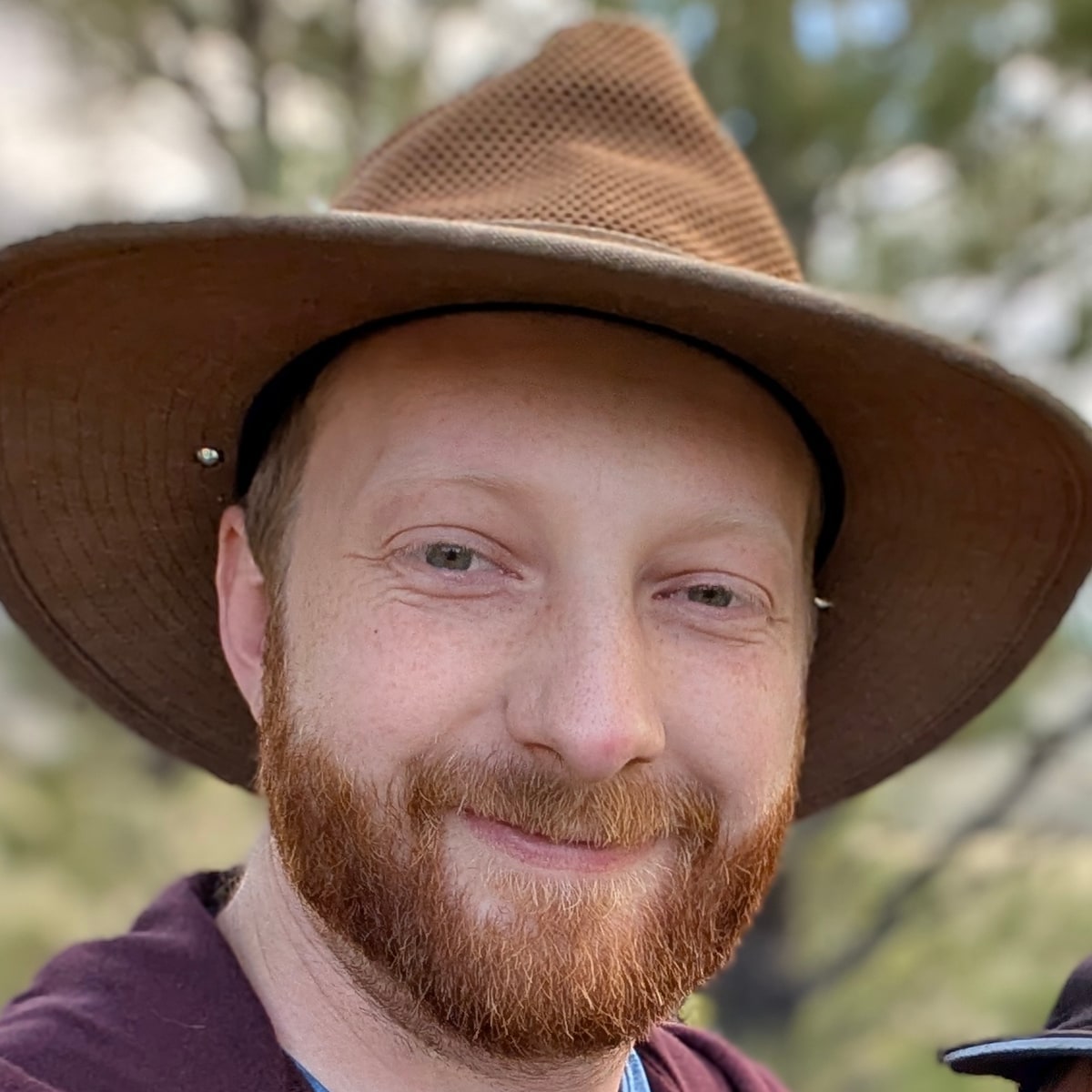 John Waters, founder of Milepost, in a wide-brimmed hat outdoors.